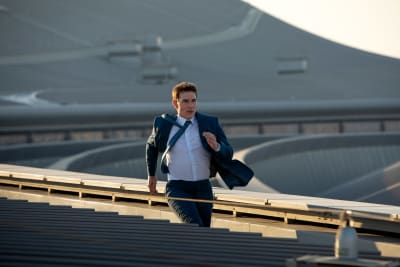 En man i kostym springer på taket av en flygplats.