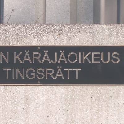 En skylt på en mur där det står Västra Nylands tingsrätt på svenska och finska.