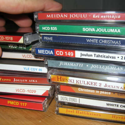 Joulumusiikkicd-levyjä pinottuna pöydällä.
