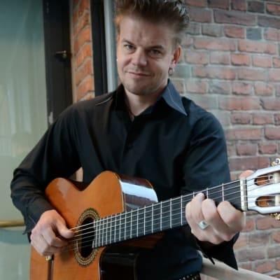 Muusikko Ilkka Esselström akustisen kitaran kanssa