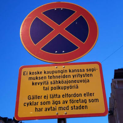 Kuvassa uusi puna-kelta-sininen liikennemerkki, joka määrittää sähköpotkulautojen pysäköinnin Helsingin keskusta-alueella.