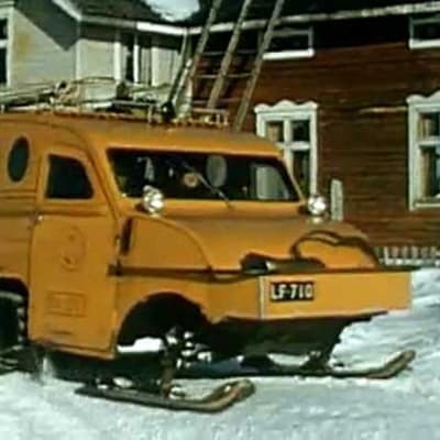Postin telaketjuilla varustettlu lumiauto, joka liikennöi 1960- ja 1970-luvuilla Lapissa.