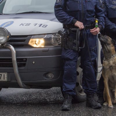 Poliisikoira ja -auto sekä kaksi poliisia.
