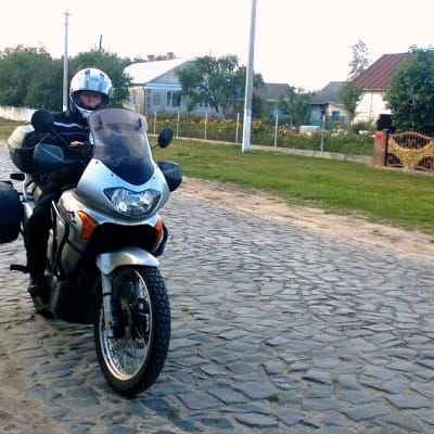Minna Jokinen moottoripyöränsä selässä Ukrainan maaseudulla