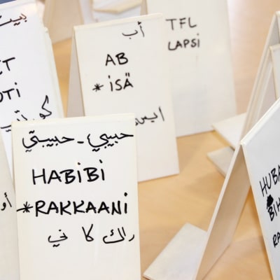 Arabian kielisiä sanakylttejä pöydällä.