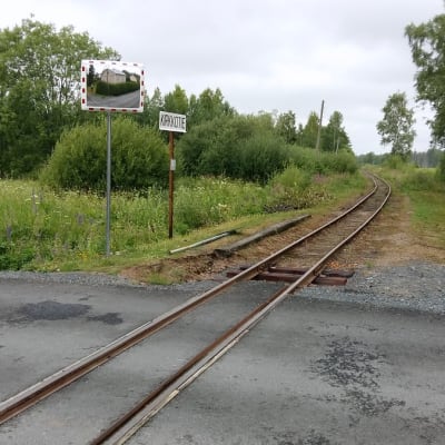 Asfalttitie ylittää kapearaiteiden rautatien