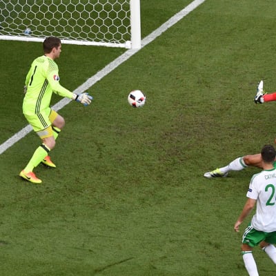 Pohjois-Irlannin Gareth McAuley liukuu pallon omaan maaliin.