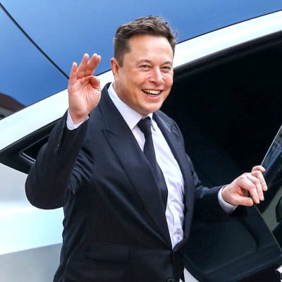 Elon Musk vinkar och ler medan han går in i en bil.