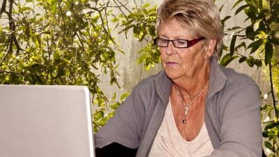 En äldre dam vid en dator. 