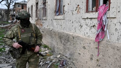 Rysk soldat utanför ett hus i Ukraina.