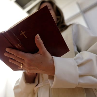 Pappi lukee raamattua.