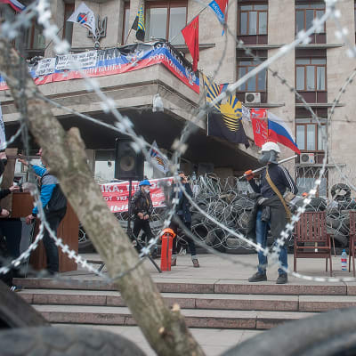 Venäjä-mielisiä mielenosoittajia barrikadilla ympäröidyn ja vallatun hallintorakennuksen edustalla.