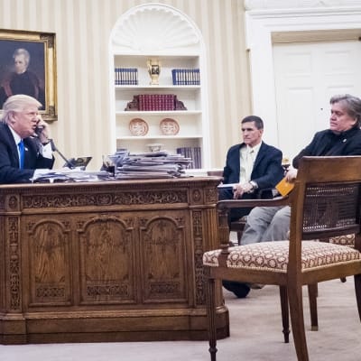 Yhdysvaltain presidentti Donald Trump hoitamassa dipolomaattisia suhteita puhelimitse. Huoneessa ovat myös kansallisen turvallisuuden neuvonantaja Michael Flynn (keskellä) ja presidentin pääneuvonantaja Steve Bannon (oikealla).