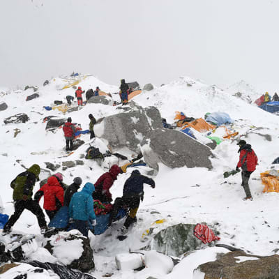 Räddningsarbetare bär de som skadats i lavinerna som utlöstes efter jordbävningen i Nepal.