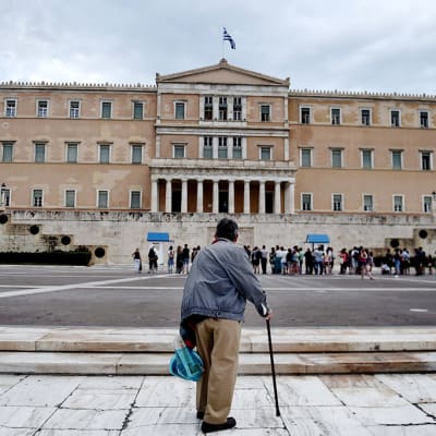 Vanha mies seisoo Kreikan parlamentin edustalla Ateenassa 27. kesäkuuta 2015.