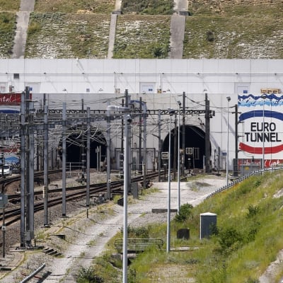 Betonitunneliin johtavat junakiskot. Seinässä lukee "Eurotunnel"