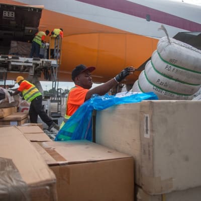Ruoka-apusäkkejä lastataan lentokoneesta Haitissa.