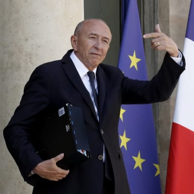 Kuvassa Gérard Collomb Élysée-palatsin ovella. Hänen vasen kätensä on ylhäällä. Takana näkyvät EU:n ja Ranskan liput.