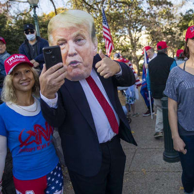 Trumpia puolustava mielenosoittaja otti itsestään selfien naamari päässä Washingtonissa lauantaina.