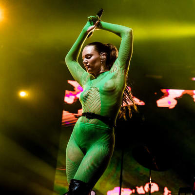 En kvinna i grön genomskinlig helkroppsstrumpa.
