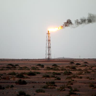 Yksinäinen kaasuliekki palaa aavikolla Khuraisin öljykentällä.