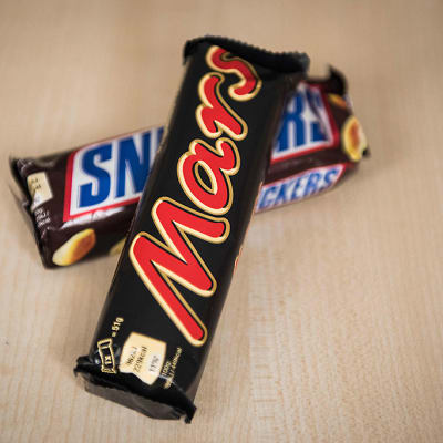 Mars- ja Snickers-suklaapatukat pöydällä ristissä päällekkäin.