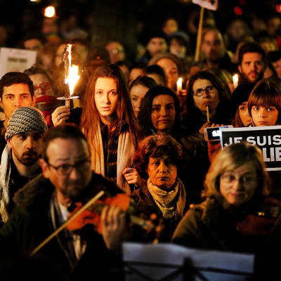 ihmisiä mielenosoituksessa kynttilöitä kädessä