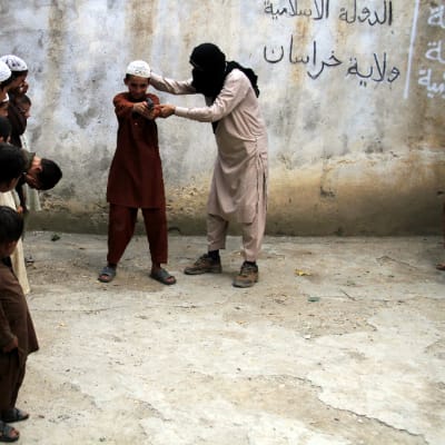 Isis-sotilas opettaa lapsia aseenkäytössä Kunarin provinssissa Afganistanissa 30. heinäkuuta 2015.