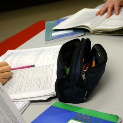 Penaali ja kirjoja opiskelijoiden käytössä pöydällä.