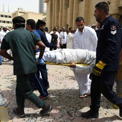 Pelastushenkilöstö kantaa iskussa loukkaantunutta ulos moskeijasta Kuwait Cityssä 26. kesäkuuta 2015.