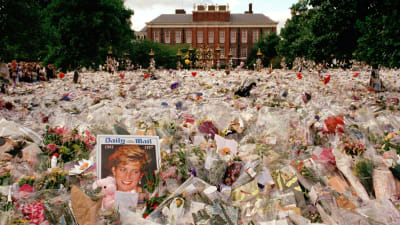 Ett blomsterhav framför en slottsbyggnad och i mitten ett fotografi av prinsessan Diana.