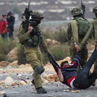Israelin sotilaat pidättivät palestiinalaisen miehen joka oli heittänyt kiviä Beit Elissä, lähellä Ramallahin kaupunkia 7. lokakuuta.