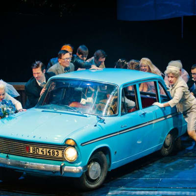 Lahden kaupunginteatterin näyttelijät työntävät Hillman-autoa.