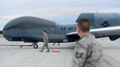 Obemannad drönare RQ-4 Global Hawk med servicepersonal på flygplats i Alaska.
