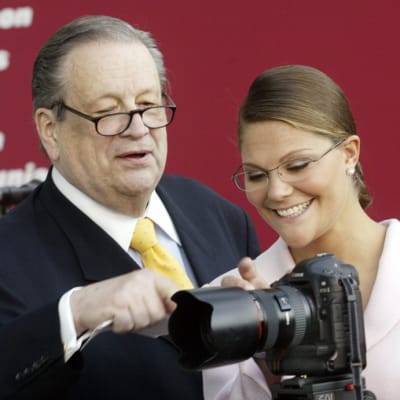 Aatos Erkko näyttää prinsessa Victorialle, mitä kameran nappia painaa.
