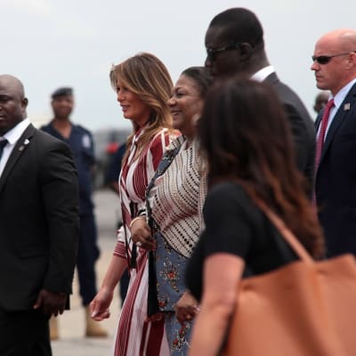 Melania Trump ja Rebecca Akufo-Addo kävelevät turvamiesten ja muun väen ympäröimänä lentokentällä.