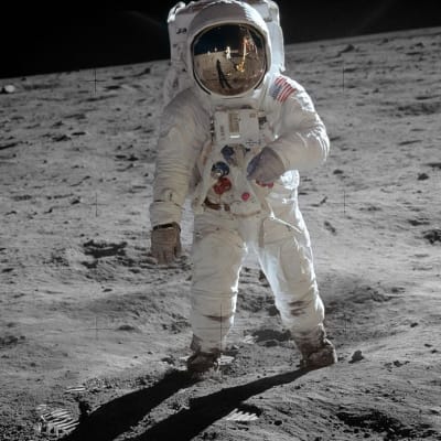 Astronautti kävele Kuun pinnalla. Pölyssä näkyy jalanjälkiä.