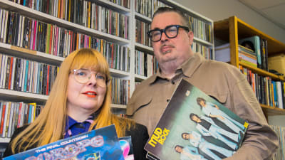 Musiikkitoimittajat Susanna Vainiola ja Pekka Laine seisovat työhuoneen levyhyllyn edessä vinyylilevyt käsissään maaliskuussa 2022.