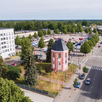 Kaupunki, kuvan keskellä punainen rakennus jota ympyröi lipputangot.