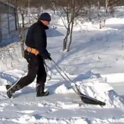 En man som skottar snö