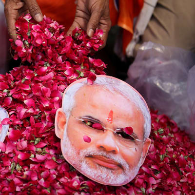 Hindunationalistisen BJP-puolueen Narendra Modia esittäviä naamareita ruusupedillä.