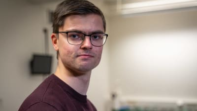 Manlig teknologstuderande med glasögon och röd tröja