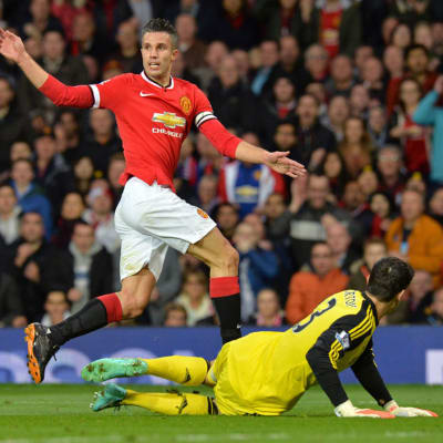 Manchester Unitedin Robin Van Persie yrittää maalintekoa Chelsean Thibault Courtois'ta vastaan.