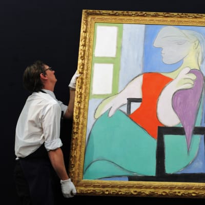 Sothebyn työntekijät ripustavat Picasson maalausta.
