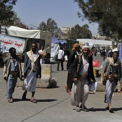 Aseistetut Houthi-liikkeen kannattajat kävelivät protesti-leirin alueella Sanaassa, Jemenissä 17. elokuuta 2014.