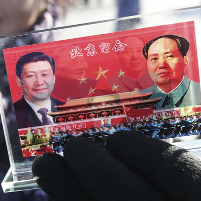 Muoviteline, johon on upotettu Xin ja Maon sekä marssivan armeijan kuvat. 