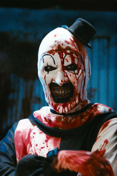 Art the Clown (David Howard Thornton) i närbild där hen står lutad mot en vägg och är helt nerblodig.