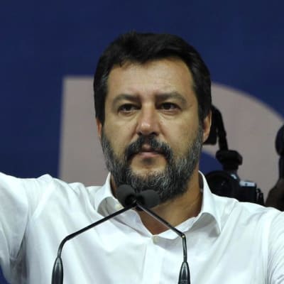 Matteo Salvini håller tal och sträcker ut handen.