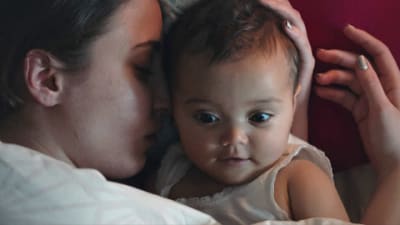På bilden syns skådespelaren Madeleine Martin hålla i en bebis i serien "Amningsrummet".