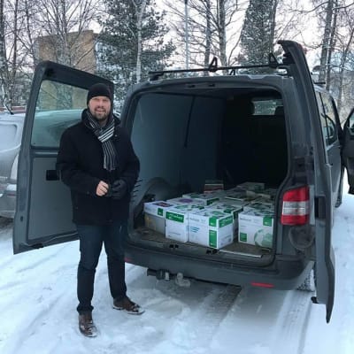 Kim Berg står framför paketbil med 18 lådor med namn.